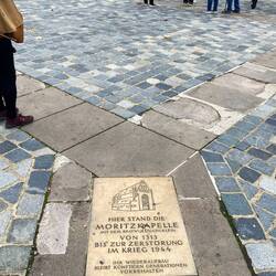 Brown flagstones outline the footprint of a bombed building.