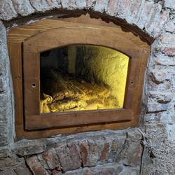 Crypt with a viewing window. It looks like the coffin collapsed and you can see braided hair inside.