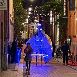 A couple of dudes on stilts, in costumes that glowed