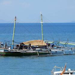 Traditional boat anchored just offshore.