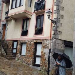 Frau im Regen auf schräger Kreuzung