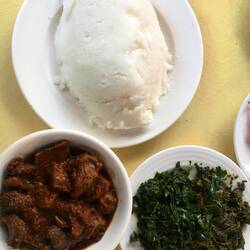 Ugali (zäher, geschmacksneutraler Maisbrei) mit Ziege, Rindereintopf, Innereien und Sukumawiki (Kohl