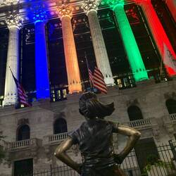 The Fearless Girl staring down the NY Stock Exchange, which was lit up on Olympic colors.