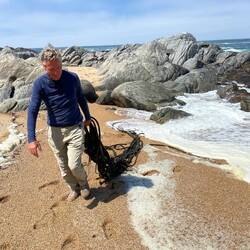 Martin holt Seetang aus dem Wasser.