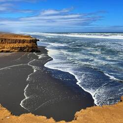 Menschenleerer Strand, schwarzer Sand, eiskaltes Wasser, viel Wind
