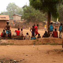 Iets verderop is een ploeg aan het voetballen. Sommigen blootsvoets, maar iedereen in voetbaltenue.
