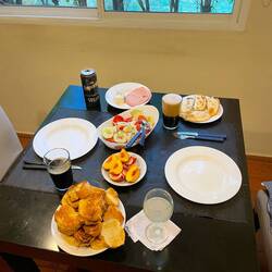 Abendessen mit Empanadas, Obst, Salat, Brot und dunklem Bier