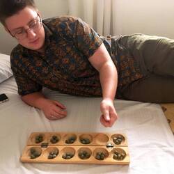 Awalé is één van de oudste Afrikaanse bordspellen. Mensen spelen het overal op straat.