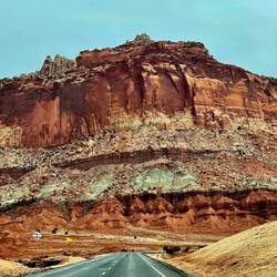 The road is dwarfed by the enormity of the rock formations