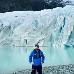kleiner begeisterter Mensch vor großem Gletscher