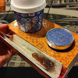 Mit geschlagener Sahne, einem Zuckerstick. Alles aus Holz/Karton.