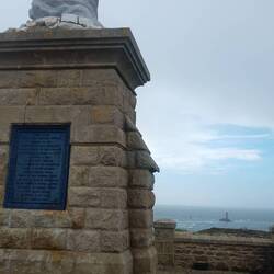 Statue für die Opfer der Meere, im Hintergrund der Leuchtturm