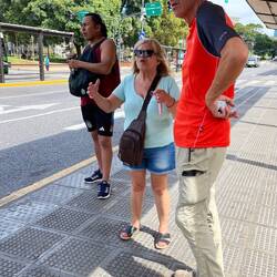Wir warten in der Hitze auf den Bus. 34 Grad. Martin im Gespräch mit einer wartenden Dame.