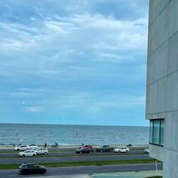 Wir sitzen hinter Glas und blicken aufs Meer.