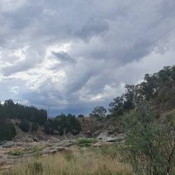 Storm clouds gathering over Adelong River and gold field ruins