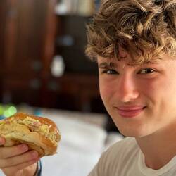 Elias hat einen leckeren Burger gemacht mit Eier, Schinken und gebratene Nudeln