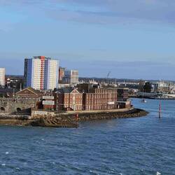 Narrow harbour entrance with Georgian buildings and a much older stone wall