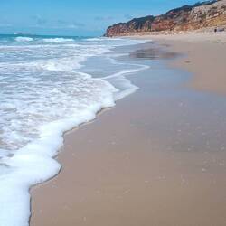 Der Strand geht in Klippen über, dahinter liegt dann Cadiz