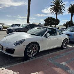 Porsche cars are common in the beach area.