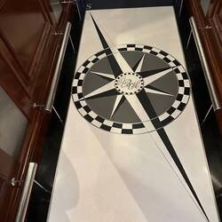 The floor of the elevator - emblem in the middle is OBH - Oyster Bay Hotel