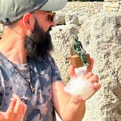 Arkeologen med en kopia av en liten statyett som hittades under utgrävningarna.