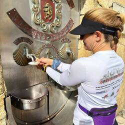 Angela pours some wine into her shell at Irache