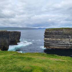 Dun Briste (the sea stack) dwarfs the WWII lookout tower.