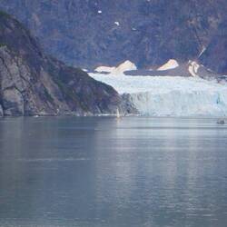 For scale, there is a sailboat to the left of the glacier in front of the cliff.