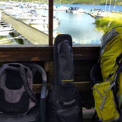 Hiking backpack on the back, regular backpack on the front and guitar on the side