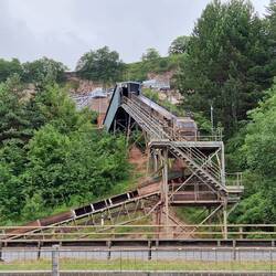 Quarry above the A55 dual carriageway sending its output to a conveyor running beneath the A55
