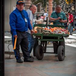 Security of a street restaurant with a towel to expel homeless people
