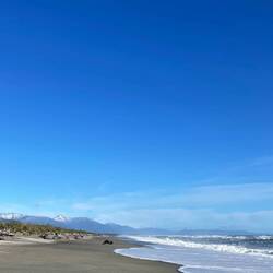 Schneebedeckte Gipfel und Sandstrand