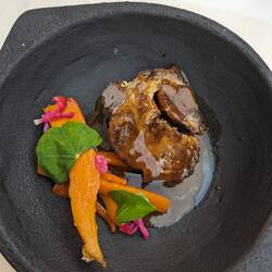 Slow braised pork back with vegetables, nasturtium leaves, and fuschia?