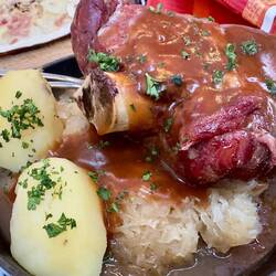 WAEDELE (PORK KNUCKLE), Munster cheese sauce with sauerkraut, cabbage, and potatoes.