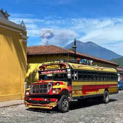 Einer von vielen Chicken busses, die im Zentrum verkehren 🚌, im Hintergrund eruptiert der Fuego 🌋