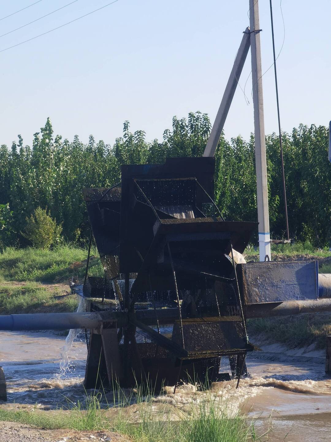 Ein Wasserrad, das Wasser aus dem Kanal auf die Felder transportiert.