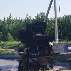 Ein Wasserrad, das Wasser aus dem Kanal auf die Felder transportiert.