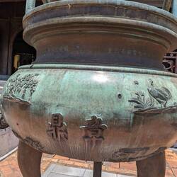Bronze urn with bullet hole