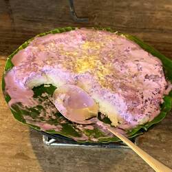 Das ist ein süsses Reisgemisch mit Kokos in Bananenblätter und Ubecreme drauf :))