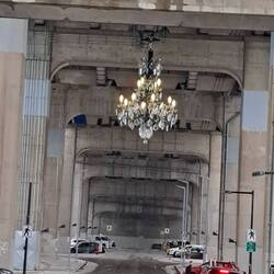 Ein verwirrender Kronleuchter unter einer vierspurigen riesigen Brücke