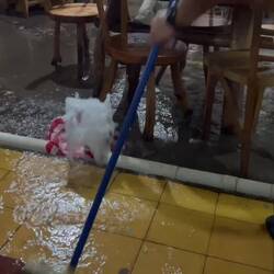 Restaurantpersonal versucht die Wassermassen in den Griff zu bekommen 💦