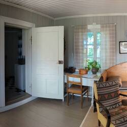A panoramic view of the tiny cabin. Note the old furniture/wood stove and wooden flooring