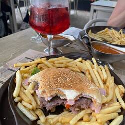 Hamburger with ham, cheese, lettuce and tomoato, fries and a Somersby. 11€