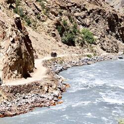 Afghanische LKWs auf unbefestigter Straße gegenüber.