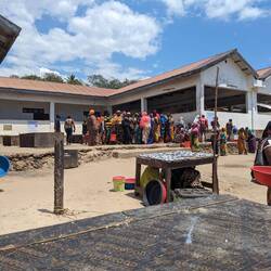 Lined up to buy buckets of tiny (anchovy sized) fish