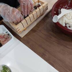 Placing sushi rice, kombu and sea bream into the wooden box for Oshi-Sushi