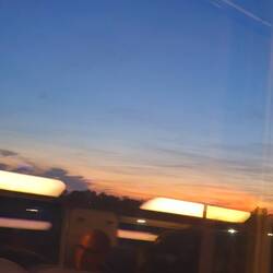 "Abendröte mit Fensterspiegelung und glatzköpfigem Mann"