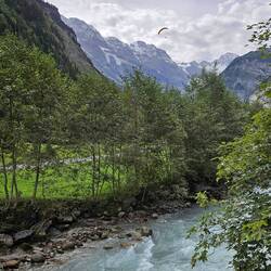Hang glider above glacial stream