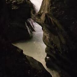 Waterfall roars down on left and rushes through chasm on right