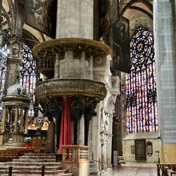 Baroque altar on left. Paintings, pillars, and magnificent stained glass